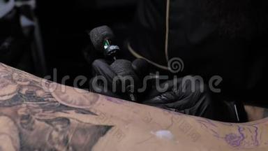 近距离纹身艺术<strong>家展</strong>示了一个客户背上有油漆的黑色纹身的过程